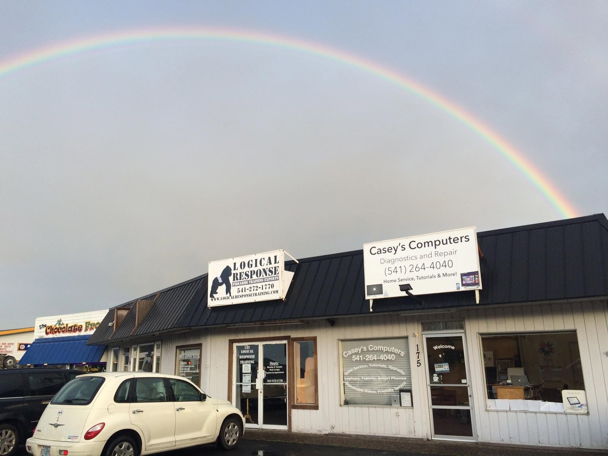 The Casey's Computers storefront in Waldport beneath a rainbow